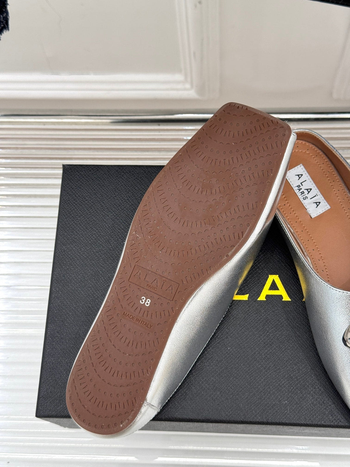 ALAIA FLAT MULE IN SILVER LAMBSKIN WITH SILVER HARDWARE